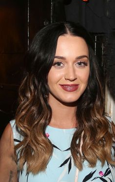 a close up of a person wearing a dress and smiling at the camera with long hair