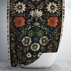 a black and white floral shower curtain with red, orange, green, blue flowers on it