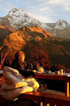 a woman sitting at a table in front of mountains with a quote on it that reads, when you really pay attention, everything is your teacher