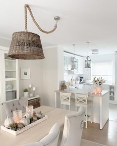 a dining room table with chairs and a basket hanging from the ceiling