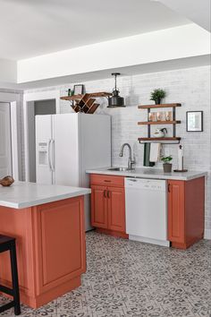 an orange and white kitchen is shown with tile flooring, cabinets, and counters