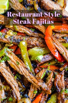 steak fajitas with peppers, onions and limes on a white platter