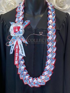 a black graduation gown with red, white and blue ribbon around it's neck