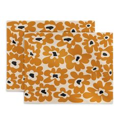 two orange and white paper napkins with black dots on the bottom, one has an image of flowers