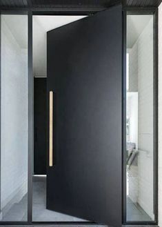 an open black door in the middle of a room with white walls and flooring