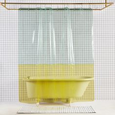 a yellow bath tub sitting in front of a shower curtain with grids on it