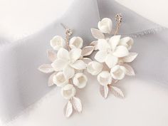 two white flowers are attached to silver ear wires