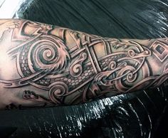 a man's arm with an intricate tattoo design on the arm and shoulder area