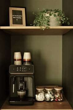 a coffee maker and some jars on a shelf