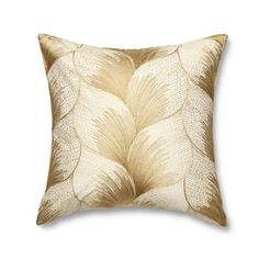 a gold and white pillow with leaves on it's back, in front of a white background