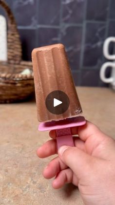 a hand holding an ice cream cone on top of a counter