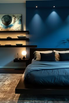 a bed with blue sheets and pillows in a room that is lit up by lights