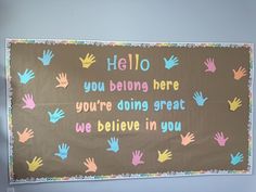 a bulletin board with handprints on it that says hello you belong here, you're doing great we believe in you