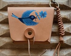 a brown leather case with a blue bird on it and a cord attached to the back