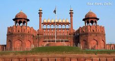 a large red brick building with two towers on top and a flag flying in the wind