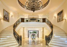 an elegant foyer with chandelier and marble floors