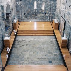 an empty room with stone walls and wooden benches