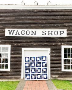 an old wooden building with a sign that says wagon shop on the front and side