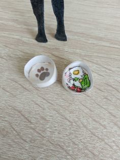 a dog paw prints on the floor next to two dishes