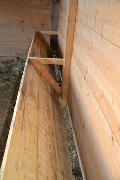 the inside of a wooden building with hay in it