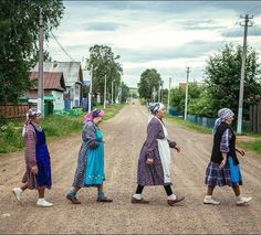 four women are walking down the dirt road