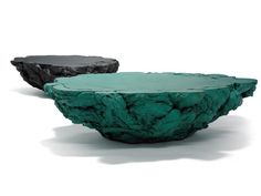 two black and green stone bowls sitting on top of each other