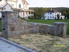 a stone wall in front of a house