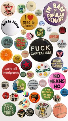 a bunch of buttons that are all different colors and sizes, with the words f c k capitalism on them