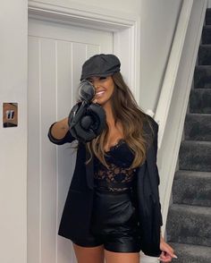 a woman in black jacket and hat holding up a camera