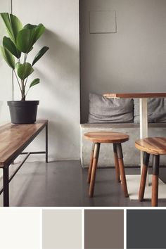 two wooden stools in front of a table with a potted plant on it