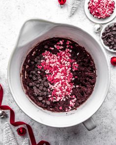 a white bowl filled with chocolate and sprinkles on top of a table