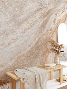 a table with a mirror and vase on it in front of a wall that has a marble pattern