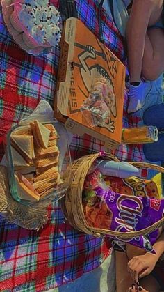 a picnic blanket with food and snacks on it