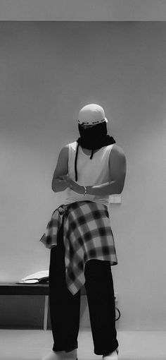 a man wearing a bandana standing in front of a desk