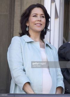 a woman standing next to a man in front of a window