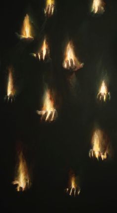 many lit hands are shown in the dark