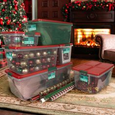 christmas decorations are stacked on top of each other in front of a fireplace and decorated tree