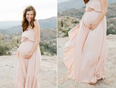 a pregnant woman in a pink dress standing on top of a mountain