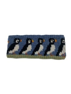 a blue and white knitted headband with black and white penguins on the side