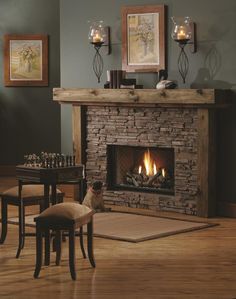 a dog sitting in front of a fire place with candles on the mantle and pictures above it