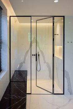 a bathroom with black and white marble flooring next to a walk - in shower