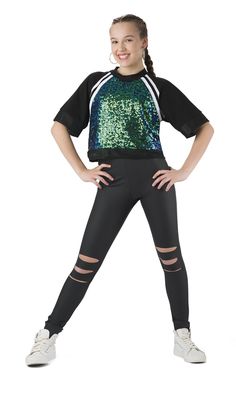 a girl in black and green sequins posing for the camera with her hands on her hips