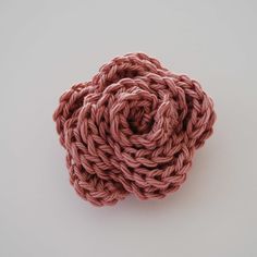 a pink knitted object sitting on top of a white table