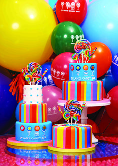 there are many colorful cakes and balloons on the table