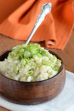 a wooden bowl filled with mashed potatoes and celery on top of a white napkin