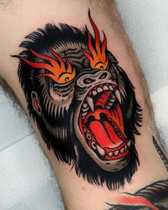 a man's arm with a gorilla tattoo on it and flames coming out of his mouth