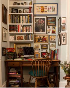 a home office with bookshelves and pictures on the wall