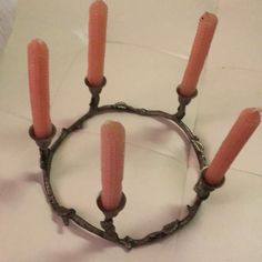 a group of four candles sitting on top of a metal ring