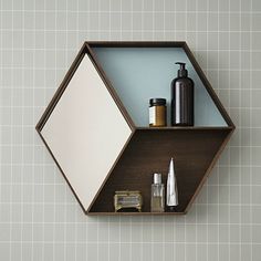 a shelf that has some items on it and is hanging from the wall in front of a tiled wall