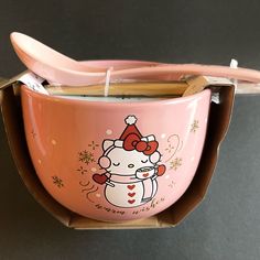 a pink hello kitty bowl with toothbrushes in it